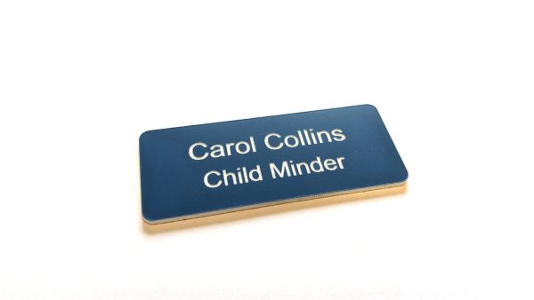 A navy blue name badge with white engraved text. With rounded corners