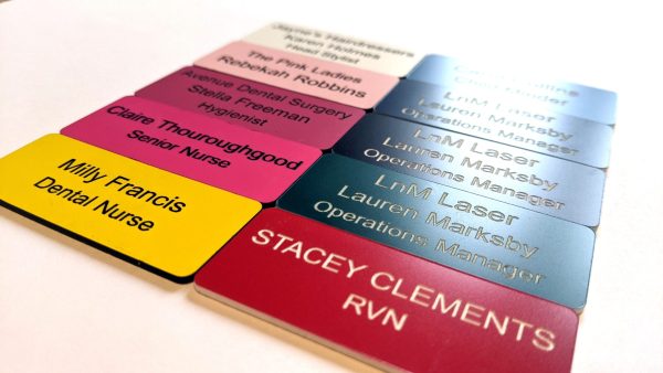 A display of personalised Engraved Coloured Acrylic Name Badges, featuring a spectrum of colours for a lively and professional touch