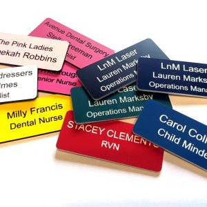 Various engraved name badges engraved with contrasting text on, With rounded corners.