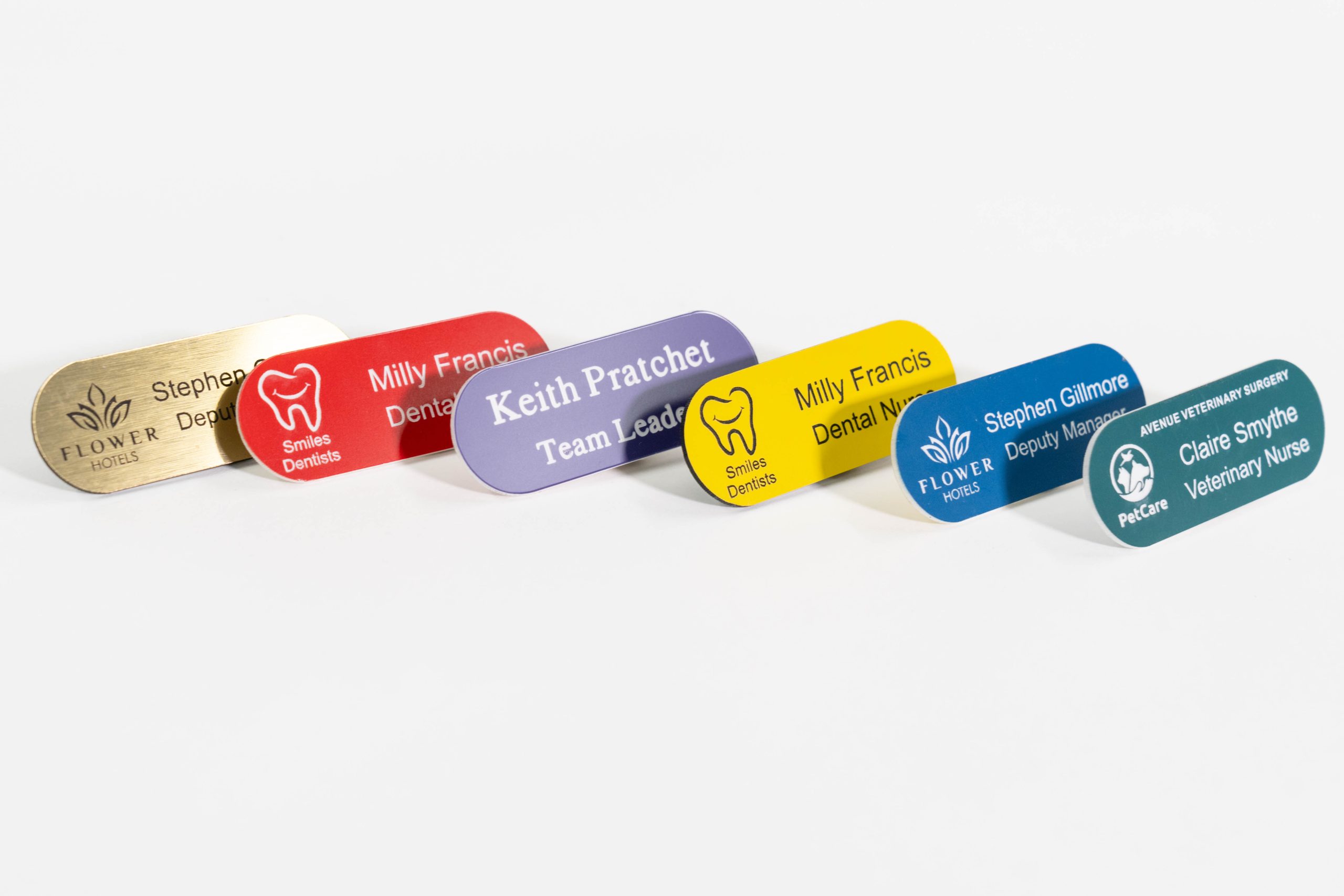 An assortment of pill shaped acrylic engraved name badges in a range of vibrant colours. These badges are made from durable acrylic material