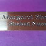Polished rectangle brass name badge, featuring black engraved text
