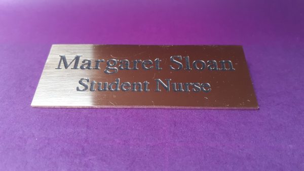 Polished rectangle brass name badge, featuring black engraved text