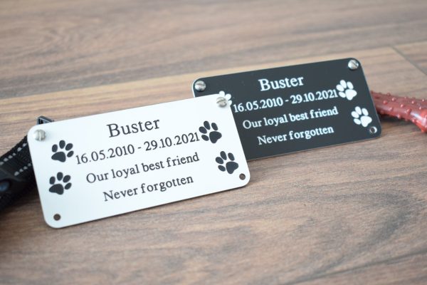 4" x 2 pet memorial plaque, Black rectangle plaque with white engraving text and rounded corners and four screw holes with two paw prints either side of the text