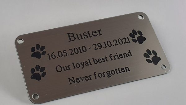 4" x 2 pet memorial plaque, silver rectangle plaque with black engraving text and rounded corners and four screw holes with two paw prints either side of the text