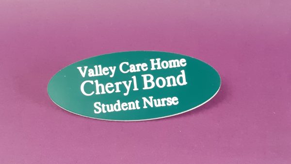 Engraved teal-green oval name badge, engraved with white text.