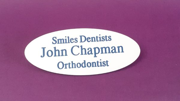 Engraved white oval name badge, engraved with blue text.