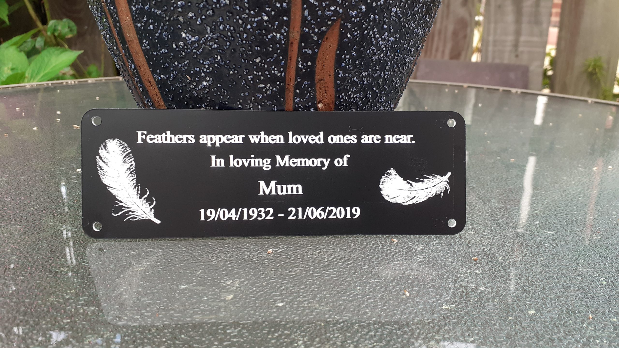 Personalised bench Plaques - 6" x 2" with decorative feathers either side of the white engraved text, 4 screw holes in each corner.
