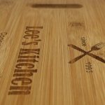 Close up of a bamboo chopping board with heartfelt engraving - 'Lee's kitchen - Cooking since 2019'