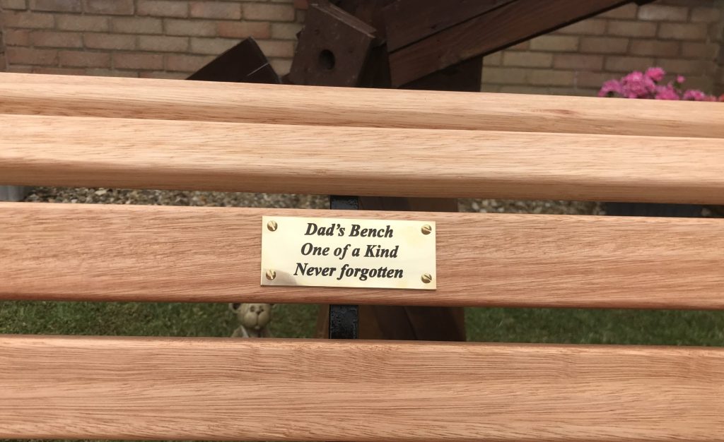 Restored wooden bench with a new brass plaque