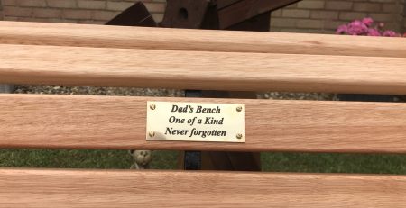 Restored wooden bench with a new brass plaque