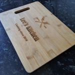 Close up of a bamboo chopping board with heartfelt engraving - 'Lee's kitchen - Cooking since 2019'