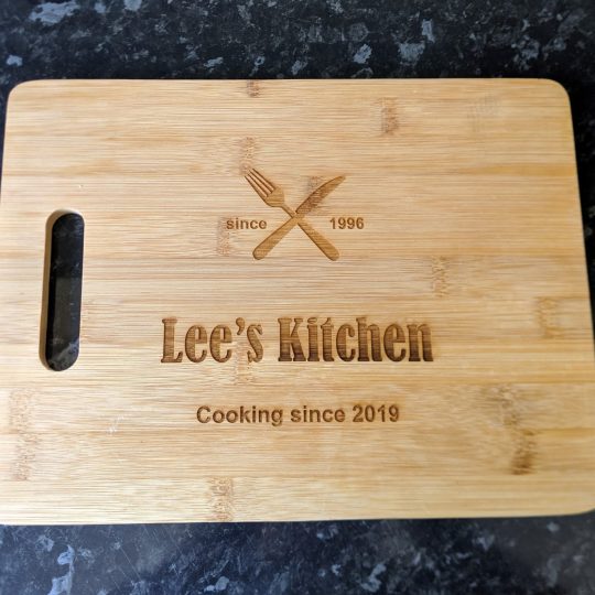 Personalised Chopping Boards Close up of a bamboo chopping board with heartfelt engraving - 'Lee's kitchen - Cooking since 2019'