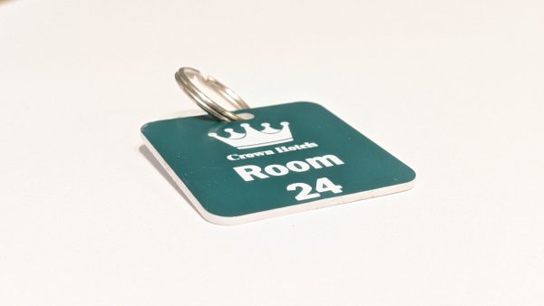Teal green keyring with white text showing a crown logo and a door number