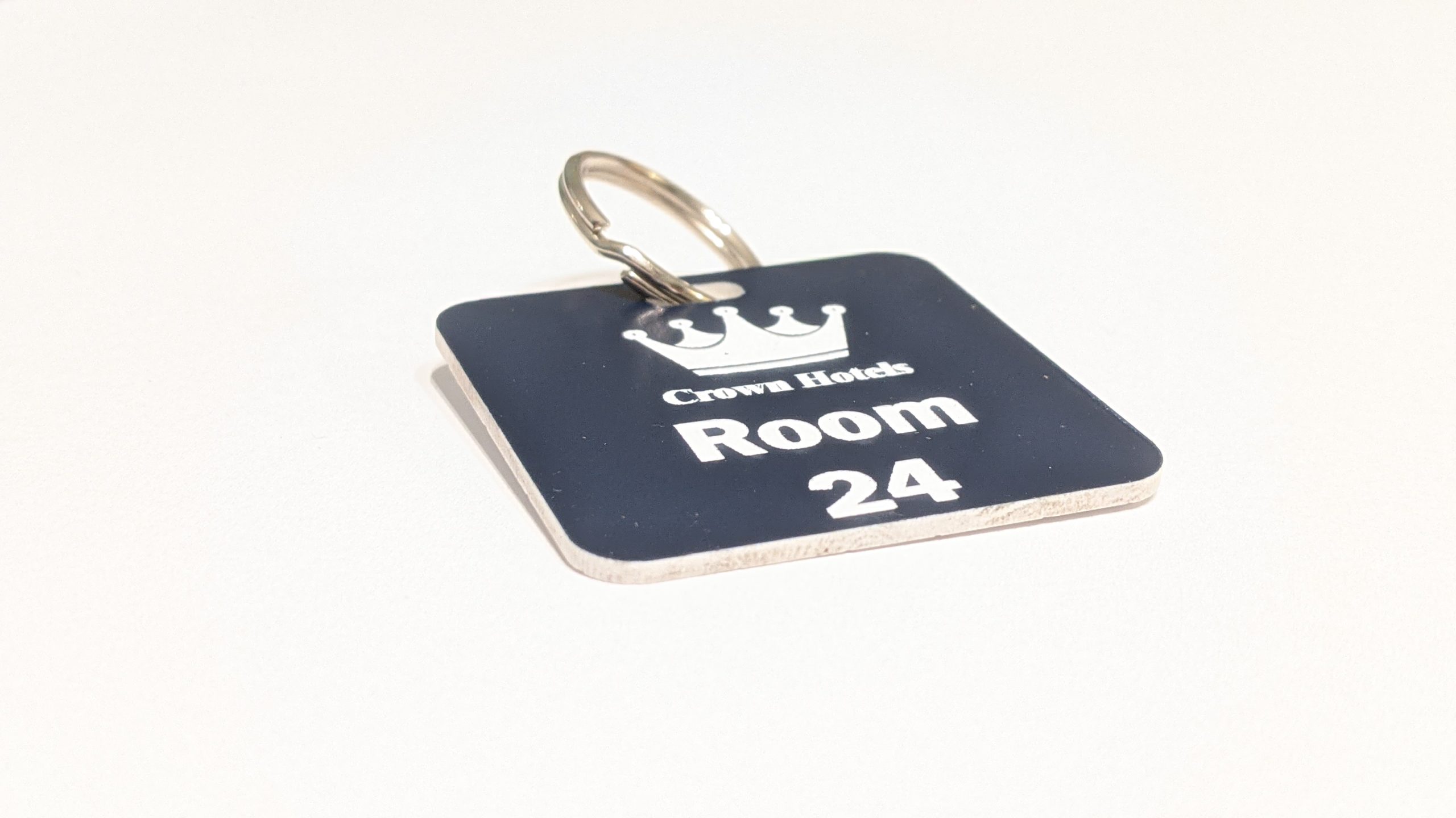 Navy Blue keyring with white text showing a crown logo and a door number