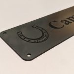 Close up of black engraving on silver Stable Name Plaque - 6" x 2" with Left-Hand Horseshoe Design