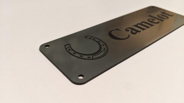 Close up of black engraving on silver Stable Name Plaque - 6" x 2" with Left-Hand Horseshoe Design