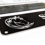 Close up of white engraving on black Stable Name Plaque - 6" x 2" with Left-Hand Horse's Head Design