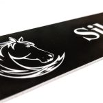 Close up of white engraving on black Stable Name Plaque - 6" x 2" with Left-Hand Horse's Head Design