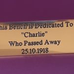 Elegant brass bench plaque, adorned with engraved text and black paint infill, secured by four sturdy screw holes.