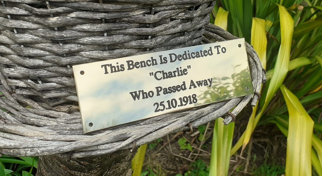 Timeless brass bench plaque with engraved details filled in black paint, designed for longevity and secured with four screw holes.