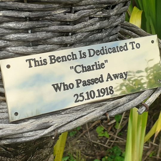 Timeless brass bench plaque with engraved details filled in black paint, designed for longevity and secured with four screw holes.