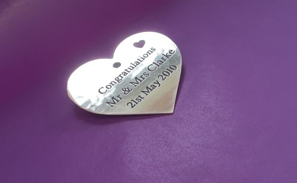 brass heart plaque with black infill, featuring a delicate small heart in the upper right corner.