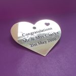 Solid polished brass heart plaque adorned with deep engravings and black infill, featuring a delicate small heart in the upper right corner.