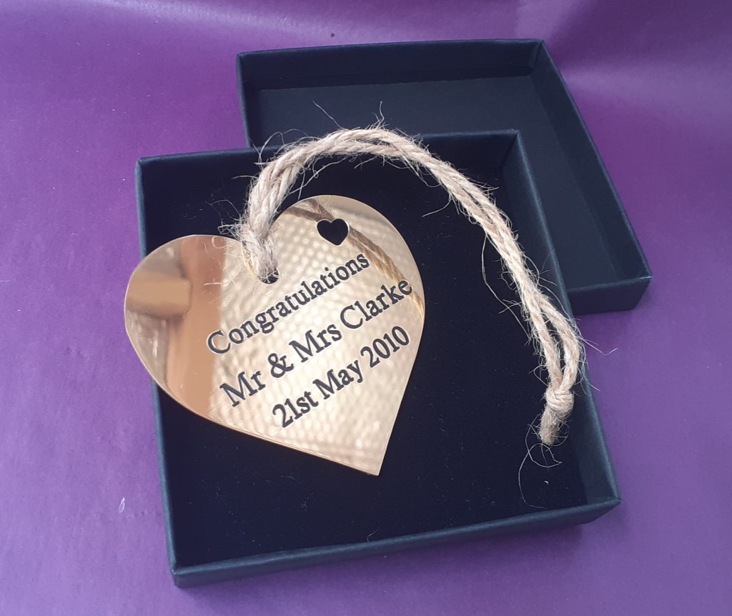 Customised brass heart plaque, meticulously engraved and accented with black infill, presented in an elegant gift box.