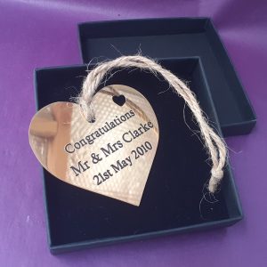 Customised brass heart plaque, meticulously engraved and accented with black infill, presented in an elegant gift box.