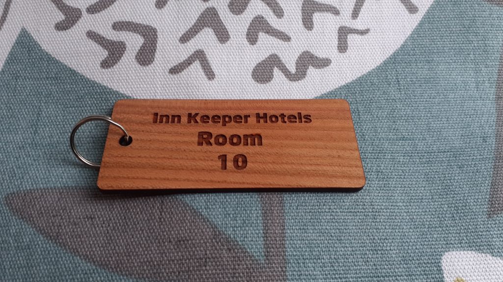 Cherry Wood Key Rings, Key Fobs 105mm x 40mm, Wooden keyring featuring detailed engravings, accompanied by a supplied split ring