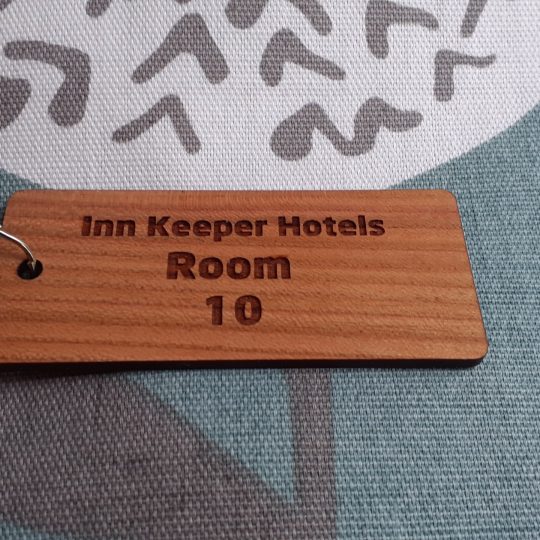 Cherry Wood Key Rings, Key Fobs 105mm x 40mm, Wooden keyring featuring detailed engravings, accompanied by a supplied split ring