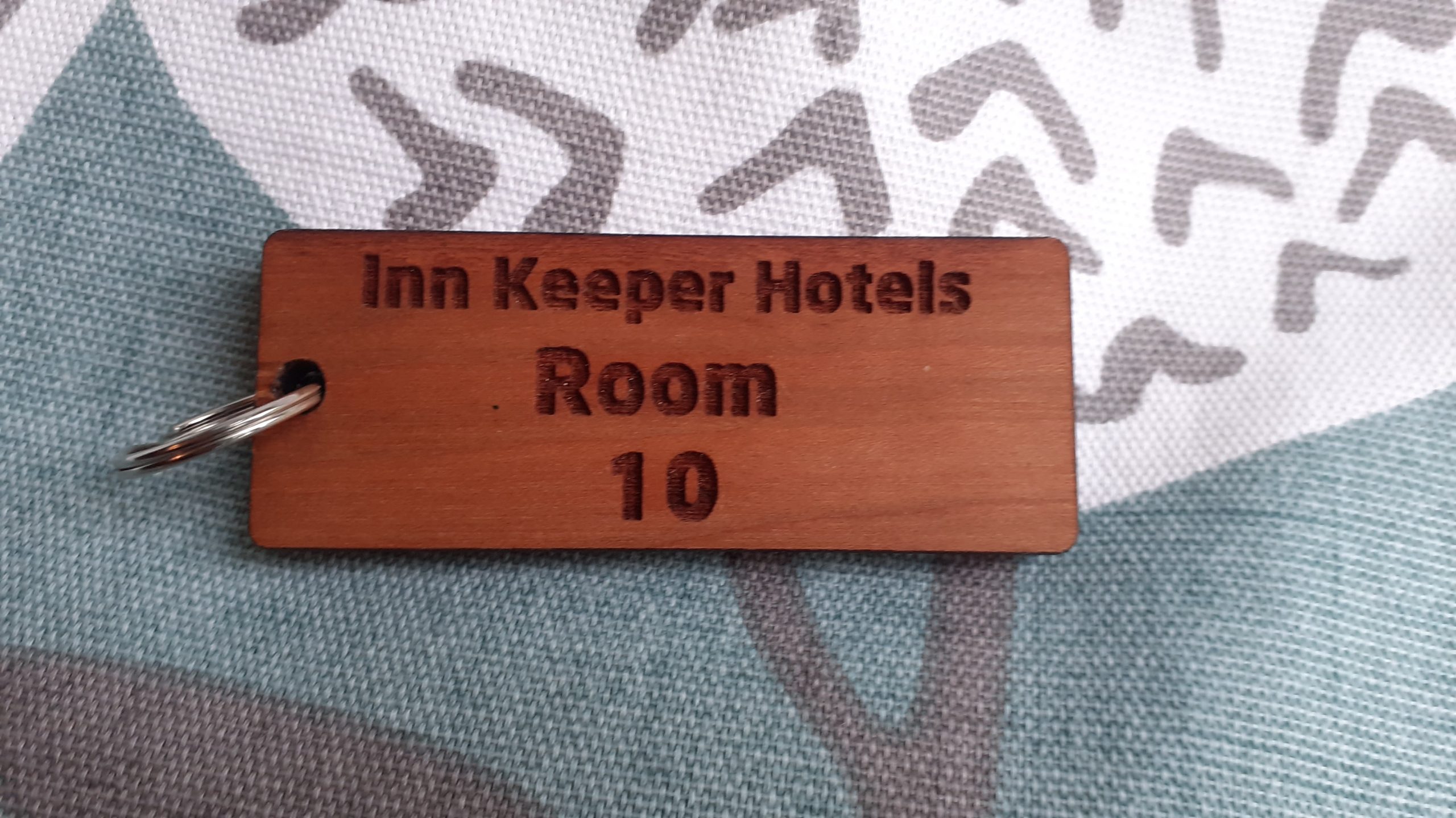 Wooden keyring featuring detailed engraving, accompanied by a supplied split ring