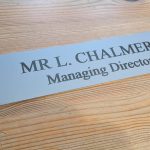 Professional-grade 10" x 2" aluminum office door label, designed for easy changes and durability.