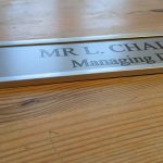 Contemporary office decor - a 10" x 2" aluminum door sign with interchangeable options and stylish aluminum holder