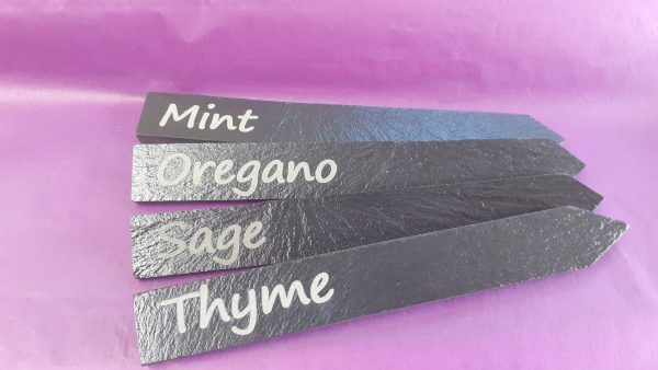 4 personalised slate plant markers with custom engravings showing Mint, Oregano, Sage, Thyme