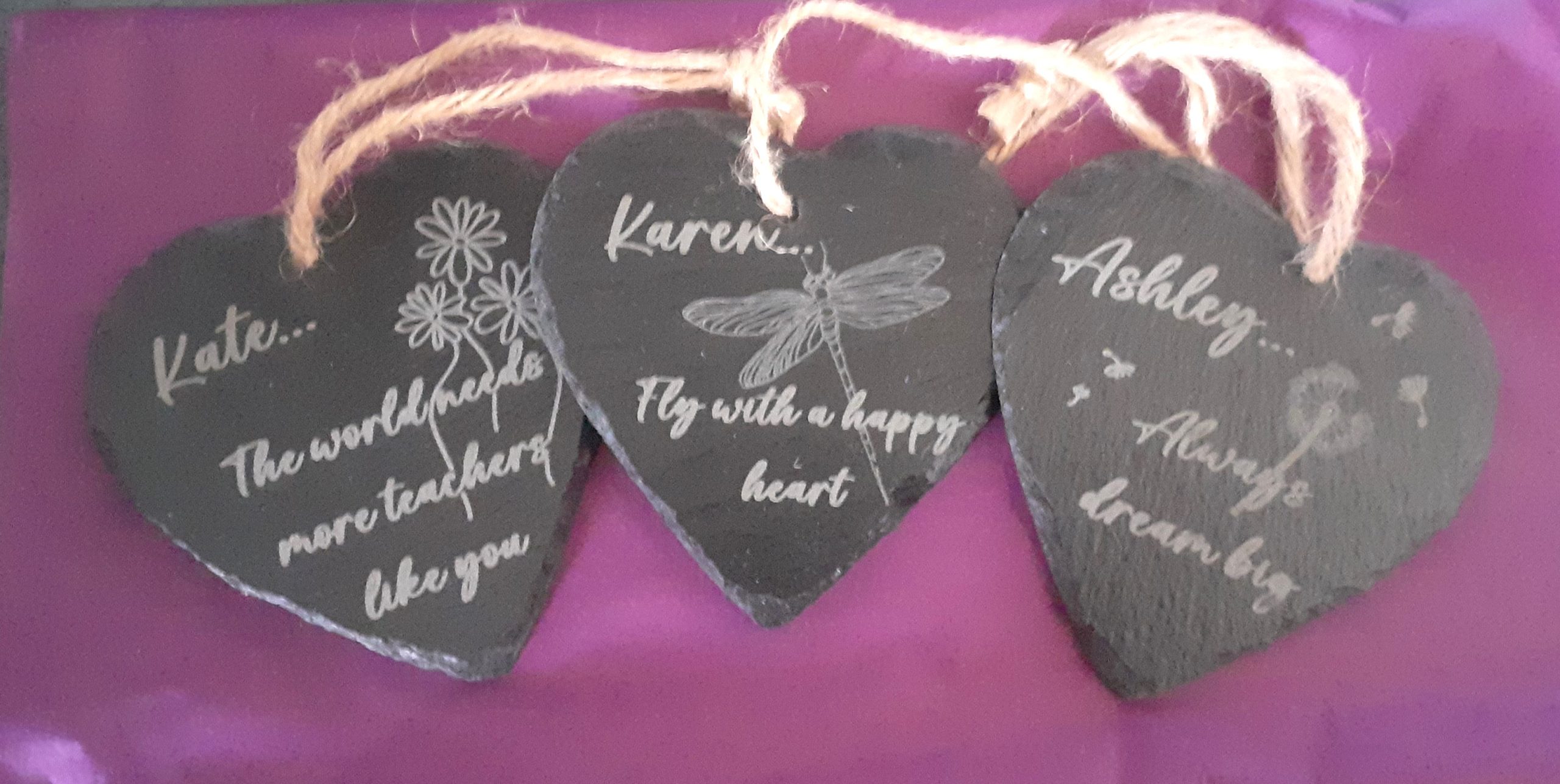 3 personalised slate hearts with custom engravings showing dragonfly, dandelion and flowers