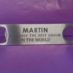 Stainless steel Bar Blade Bottle Opener with laser engraved text, showing the best groom and a person name