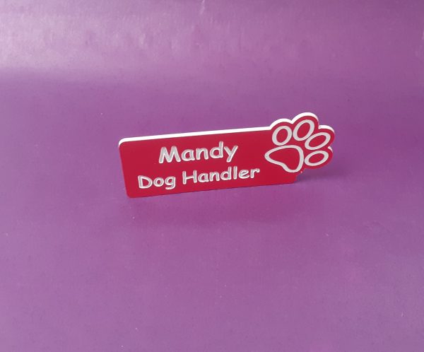 Red name badge with the paw print on the right-hand side of the name badge showing an employee name and title engraved with white text