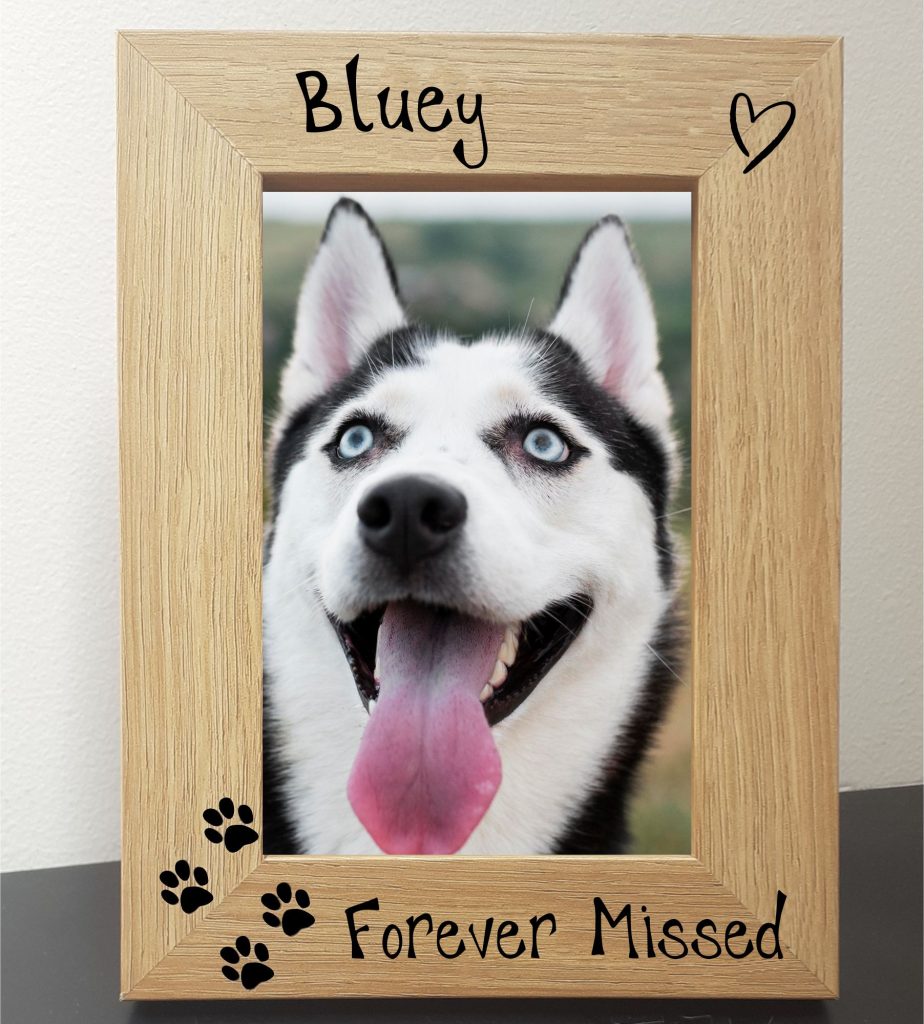Pet Memorial Photo Frames 7" x 5" An oak veneer photograph frame. It has been personalised with text etched on the frame, with the dog’s name at the top of the frame, forever missed at the bottom, 4 paw prints etched in the bottom left-hand side of the frame, a heart top right