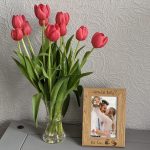 An oak veneer photograph frame. It has been personalised with text etched on the frame