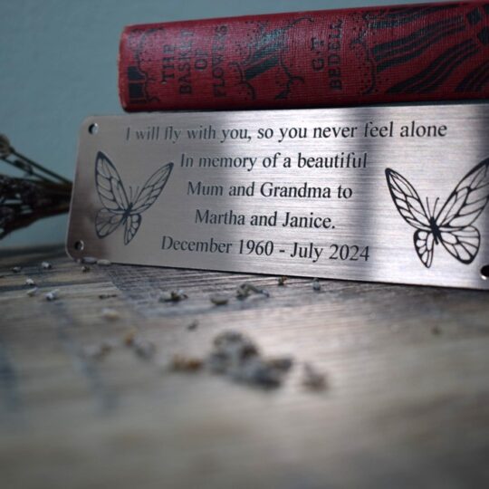Bronze Bench Plaque on a purple background showing 2 butterflies either side of text and supplied with 4 screw holes
