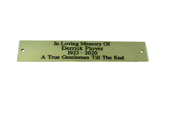 Personalised Engraved Brass Bench Plaques (150mm x 40mm), highly polished with black in-filled text and 2 screw holes on either side of the plaque showing the wording over 4 lines. In Loving Memory of on the top line, Derrick Plover on the 2nd line, 1923–2020 on the 3rd line and the 4th line A true Gentleman Till The End