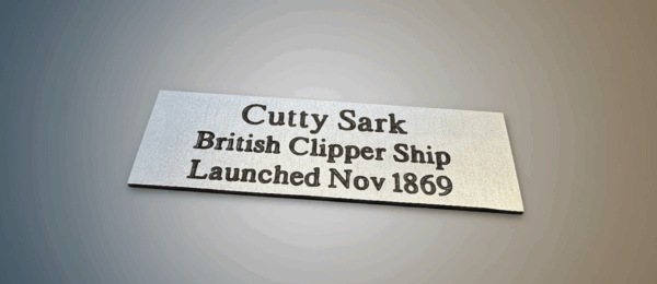 A 75mm x 25mm aluminium plaque with the text 'Cutty Sark British Clipper Ship Launched Nov 1869' on a subtle grey gradient background